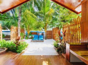 乌库拉斯武库拉斯海滩别墅的一个带蓝色椅子和棕榈树的庭院