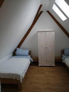 瓦尔德基尔希Ferienwohnung Maja的阁楼间设有两张床和橱柜。