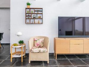 博利尔马克6 person holiday home in R m的客厅配有电视、椅子和桌子