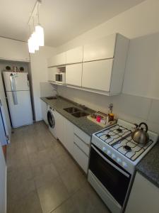 罗萨里奥Mi Lugar en Rosario - Depto céntrico VIP, 3 amb con cochera opcional的厨房配有炉灶和冰箱。