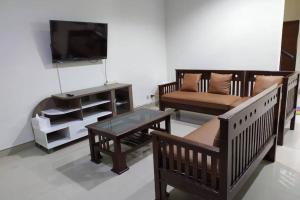 日惹Awana Dream 4 bedrooms house , 5min to Alun Alun, Kraton, Malioboro bdc的客厅配有木制家具和平面电视