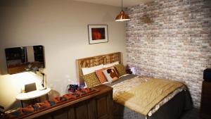 伊泽尔河畔的罗曼La Tannerie - BedinShop的一间卧室设有一张床和砖墙