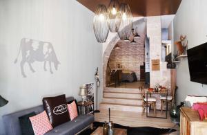 伊泽尔河畔的罗曼La Tannerie - BedinShop的带沙发和楼梯的客厅