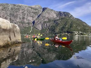 艾菲约德Adventure hotel & GuestHouse Eidfjord NEW的一群人乘皮艇在山 ⁇ 的湖上