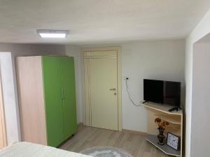 波格拉德茨Syzo Rooftop 360°的一间卧室配有绿色的橱柜和电视
