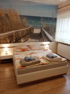 米兹多洛杰Apartament CURIE - studio的一间卧室配有一张带海洋绘画的床