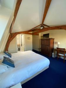 代尔夫特Hotel Bridges House Delft的卧室配有一张白色大床和一把椅子