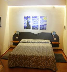 恩波利艾博尔吉旅馆的卧室配有一张墙上三幅画作的床
