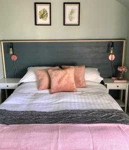 莱明斯特Archers Cottage的卧室配有一张带粉红色枕头的大床