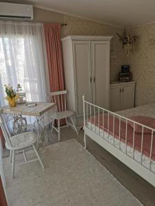 科尔卡Holiday Home Kolka的卧室配有1张床、1张桌子和1张桌子以及椅子。