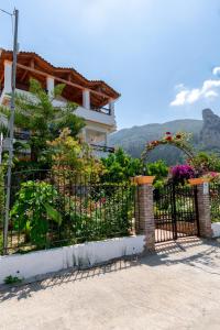 阿齐欧斯·贡多斯Villa Sophia Apartments by CorfuEscapes的房屋前有花的黑色围栏