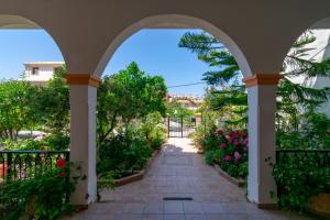 阿齐欧斯·贡多斯Villa Sophia Apartments by CorfuEscapes的穿过鲜花盛开的花园的拱形走道