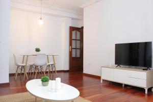 韦尔瓦Apartamento centro paseo maritimo的客厅配有平面电视和桌子。