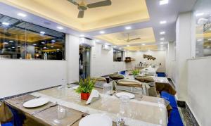 加尔各答Hotel Bandhan Residency的一间带长桌和椅子的用餐室
