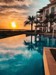 阿布扎比Yas Island的一座享有日落美景的建筑前的游泳池