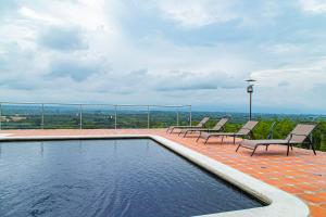 普韦布洛保Hotel Hacienda Buena Vista的一个带椅子的游泳池,享有城市美景