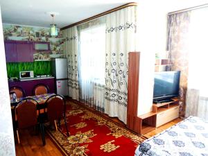 赤塔Apartment 2Pillows Bogomyagkova 11fl的客厅配有电视和桌椅