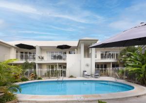 努萨维尔努萨河棕榈酒店的一座带遮阳伞的房屋前的游泳池