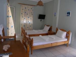 米里纳Efi Apartments (ΕΦΗ)的一间设有两张床和一张桌子的房间