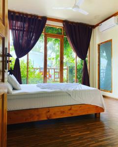 弗里德胡Bougainvillea Inn - Maldives的一间卧室设有一张床和一个大窗户