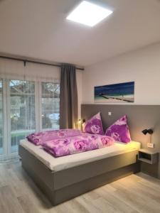 诺德代希Pension Seeufer Norddeich的卧室配有粉红色的床和窗户。
