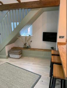 金斯林Ferry Lane Cottage的客厅设有楼梯和平面电视