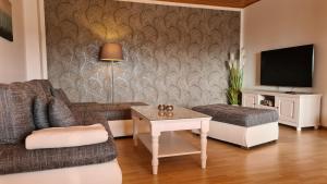 WilhelmsthalModerne Ferienwohnung mit eigenem Garten und traumhaften Blick的客厅配有沙发和桌子