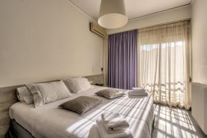 约阿尼纳阿莱克西奥斯酒店的一间卧室配有一张大床和毛巾