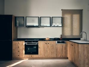 瓦西里科斯Oceanids Luxury Villas, By ThinkVilla的厨房配有木制橱柜、水槽和炉灶。