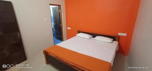 瓦拉纳西MAYUR paying Guest house的一间卧室配有一张橙色墙壁的床