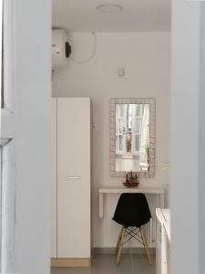 斯基亚索斯镇Aura Skiathos的白色的客房配有镜子和椅子