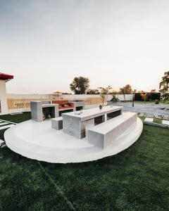 拉斯阿尔卡麦Seven Elements Resort的一组草地上的混凝土桌子