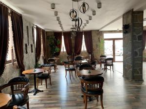 斯维伦格勒Grand Altunhan Hotel的餐厅设有木桌、椅子和窗户。