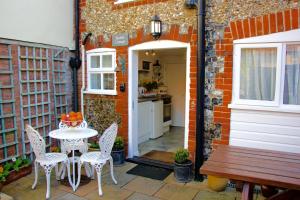 萨克斯曼德姆Romantic Flint Cottage on the Suffolk Coast的一个带桌椅的庭院和一间厨房