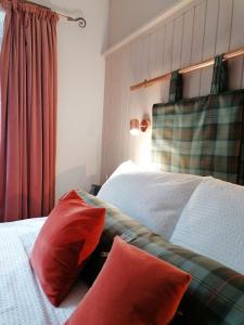 邓韦根Blas Rooms的卧室配有两张红色枕头