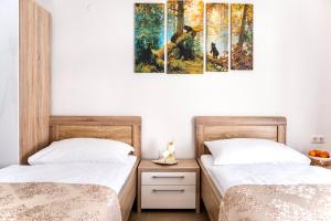 巴特霍夫加施泰因Apartments Davydov的墙上画作的房间里设有两张床