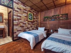 帕府班泰普古色古香民宿的一间卧室设有两张床和砖墙