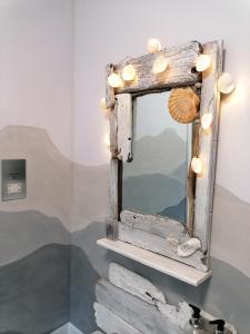 邓韦根Blas Rooms的架子上带贝壳和灯的镜子