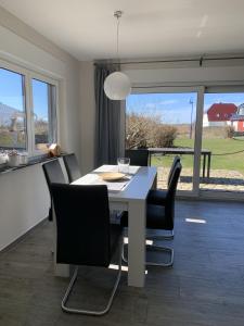 LanckenHaus Kranichfeld Wohnung T的一间配备有白色桌子和黑色椅子的用餐室