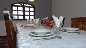 大巴萨姆Hotel Madou Grand Bassam的桌子上放有盘子和玻璃杯,花朵