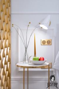 马德里Suite Kintsugi by Justine Apartments Apartamento turístico en Madrid Río的桌子上放着一碗苹果和花瓶