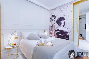 马德里Suite Kintsugi by Justine Apartments Apartamento turístico en Madrid Río的卧室配有一张大床,墙上挂有绘画作品