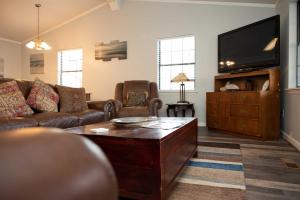 BuckheadLakefront Cottage with Private Hot Tub!的带沙发和平面电视的客厅