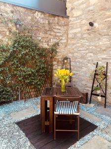 托尔诺Il borghetto di Torno的黄花花花瓶,坐在桌子上,椅子