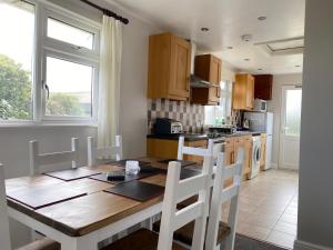 廷塔杰尔Copthorne - Tintagel的厨房配有木桌和白色椅子
