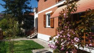 PeglioLa vedetta del Montefeltro的院子里有粉红色花的砖房