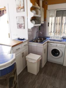 阿尔姆尼卡Casa rural en Torrecuevas的厨房配有水槽和洗衣机