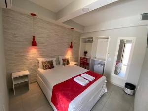 布希奥斯Pousada do Frei的一间卧室配有一张带红色毯子的大床