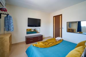 马拉加La Macarena Airport的一间卧室配有蓝色的床和电视