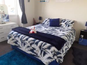 BrydoneEllie's Villa的一间卧室配有一张带蓝白色毯子的床